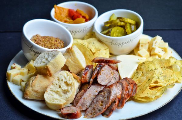 a white plate topped with different types of food next to bowls filled with pickles