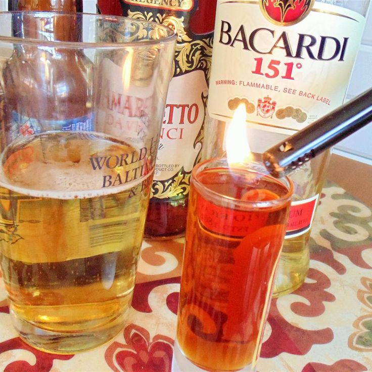 there is a candle that is in the glass next to some liquor bottles and glasses