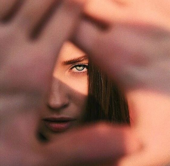 a woman looking through her fingers to see if she is in the middle of something