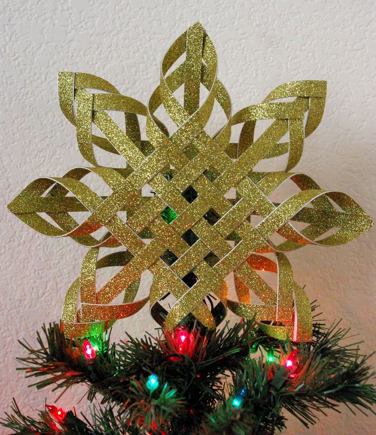 a gold snowflake with christmas lights on it's sides and decorations around the edges