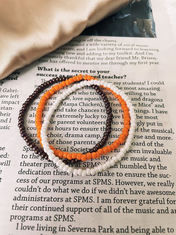 two beaded bracelets sitting on top of an open book