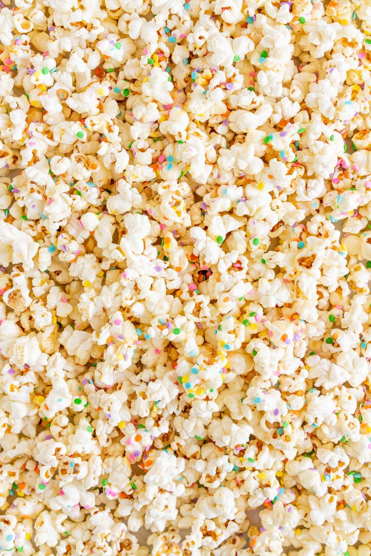 popcorn with sprinkles and multi colored confetti on the top, as seen from above