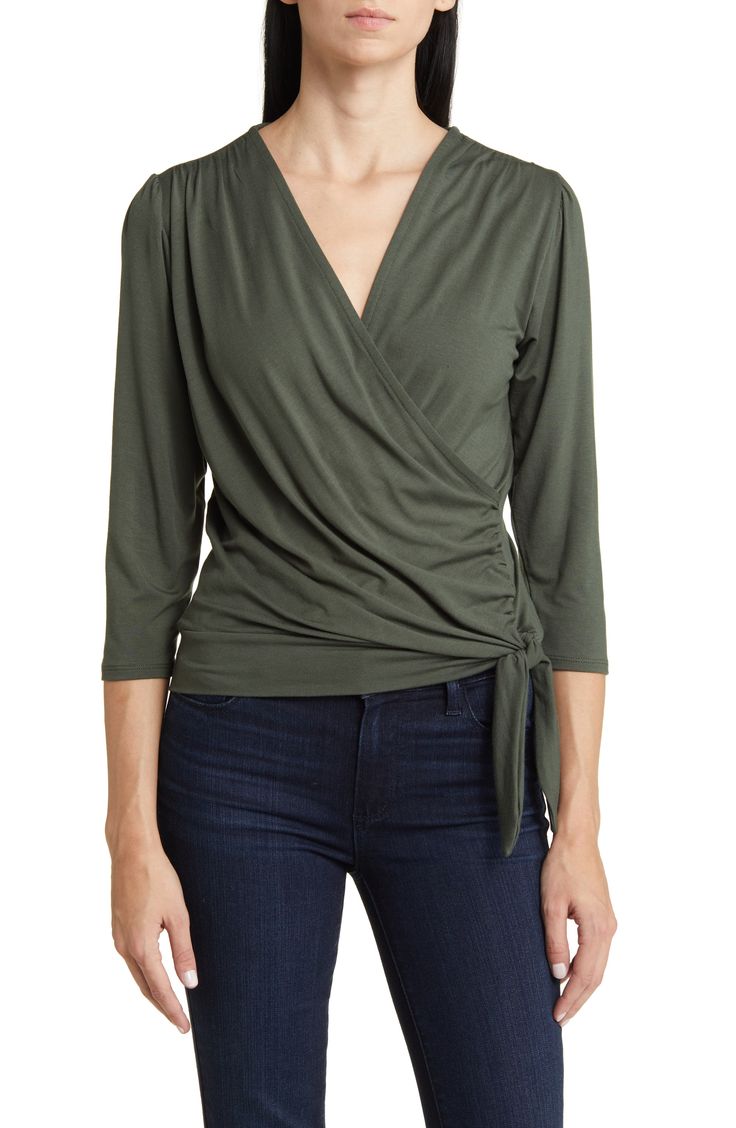 Cut from a soft, drapey jersey knit with an easy faux-wrap design, this top is an ideal choice for both casual looks or more styled up outfits. 23" length Surplice V-neck Three-quarter sleeves 95% rayon, 5% spandex Machine wash, dry flat Imported Solid Color V-neck Faux Wrap Top, V-neck Faux Wrap Top For Layering, Faux Wrap V-neck Top For Fall, Spring Casual Wrap Top For Layering, Casual Wrap Top For Spring Layering, Casual V-neck Stretch Wrap Top, Casual Stretch V-neck Wrap Top, Stretch V-neck Wrap Top For Fall, Chic Surplice Neckline Top For Layering