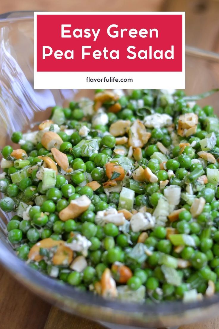 green pea salad with almonds and feta cheese in a glass bowl on a wooden table