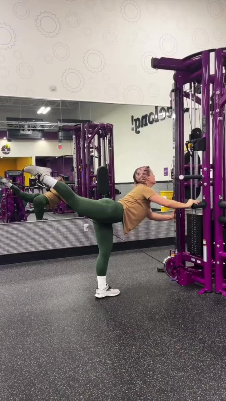 a woman doing squats on a purple exercise machine with the words follow the link in my bio for more