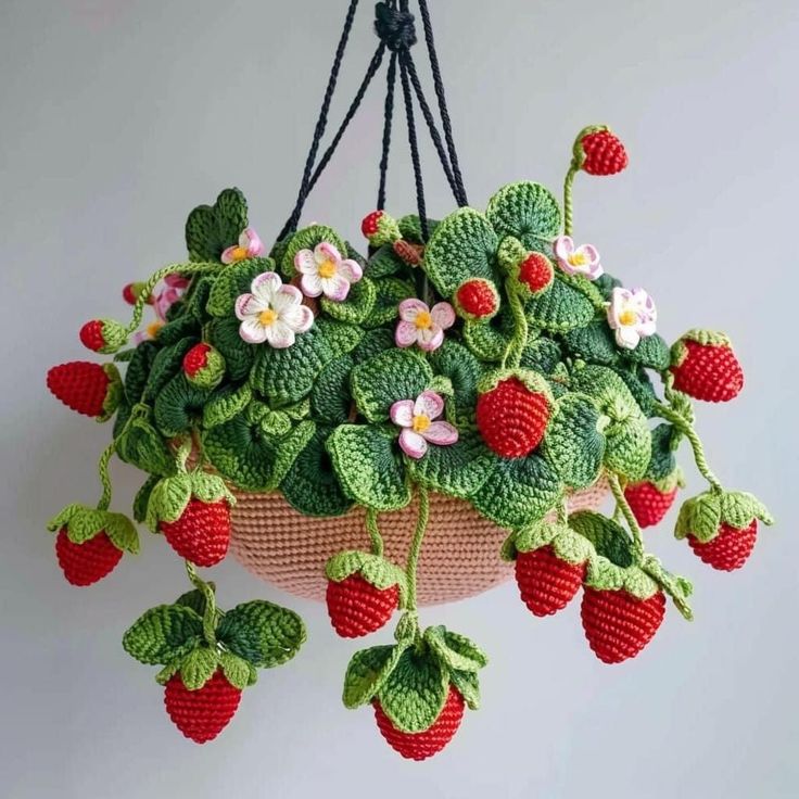 a crocheted hanging basket with strawberries and flowers