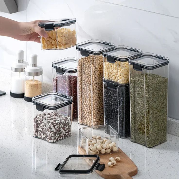 a kitchen counter with various containers and food items on it, including garlic, beans, corn, and other ingredients