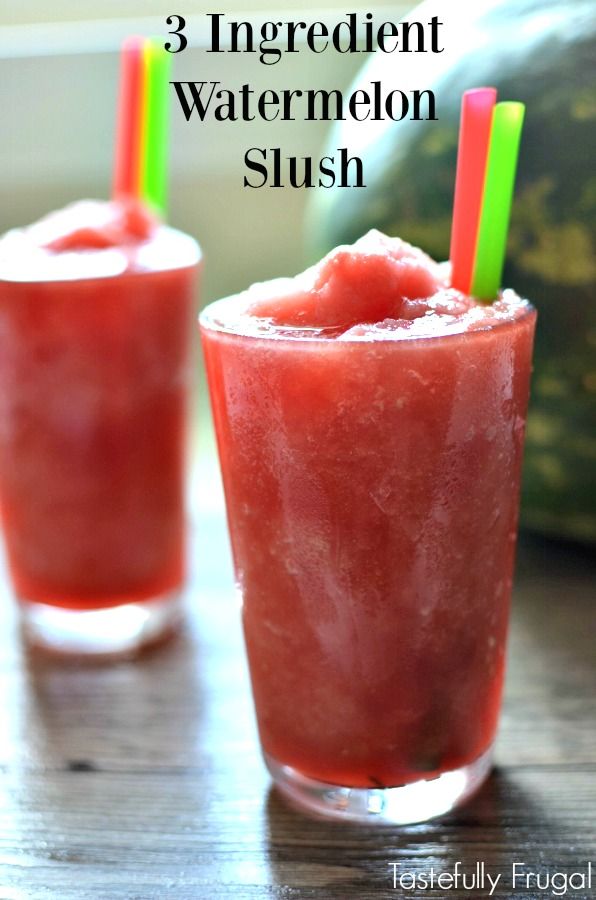 two glasses filled with watermelon slush sitting on top of a wooden table