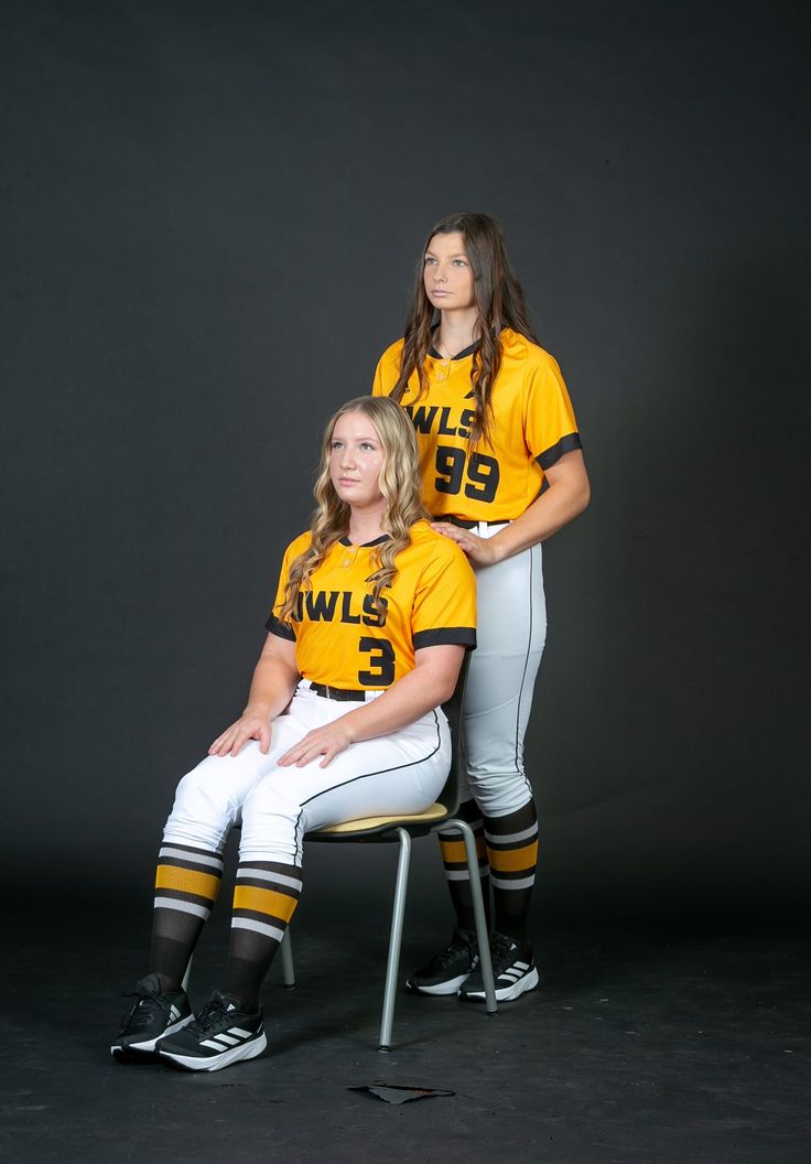 two women in yellow and white uniforms posing for a photo on a black background,