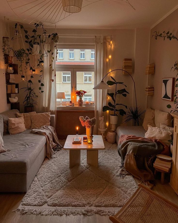 a living room filled with lots of furniture and plants on the wall above it's windows