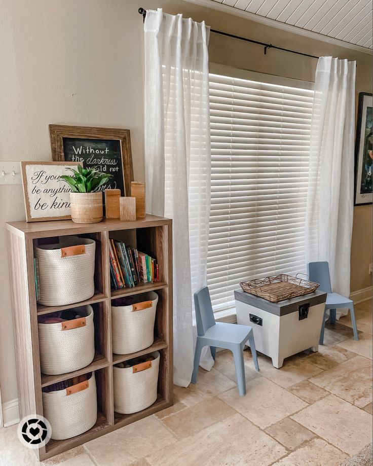 a room with several storage bins and chairs in front of a window that has white blinds