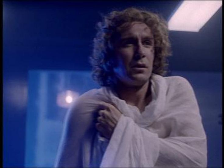 a man with curly hair wearing a white robe