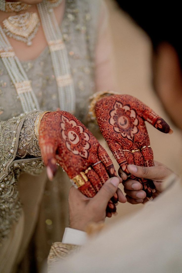 the bride and groom are holding their hands decorated with henna