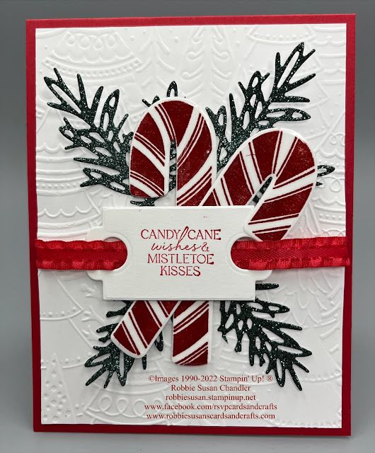 a christmas card with candy canes and ribbon on the front, which reads candy cane mistlet kisses