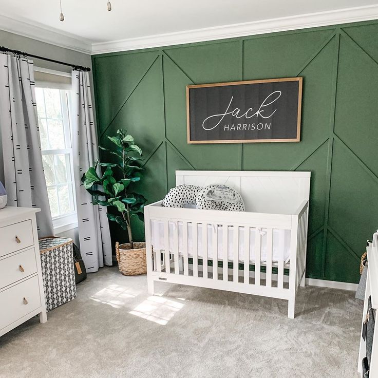 a baby's room with green walls and white furniture