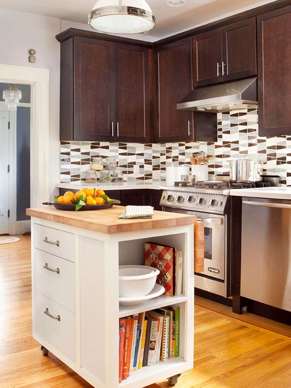 a kitchen with wooden floors and stainless steel appliances in the center, along with an island that has books on it