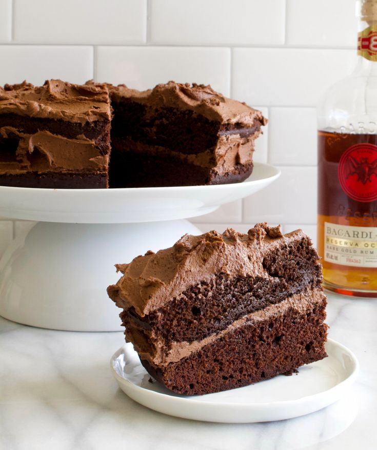 a piece of chocolate cake sitting on top of a white plate next to a bottle