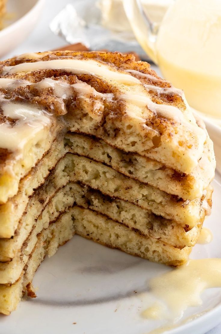 a stack of pancakes covered in icing on top of a white plate