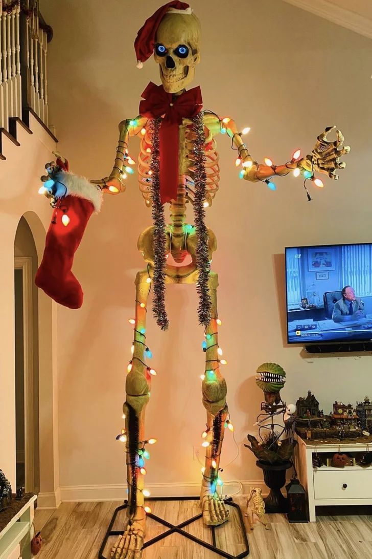 a lighted skeleton is standing in the middle of a living room with stockings on it's feet