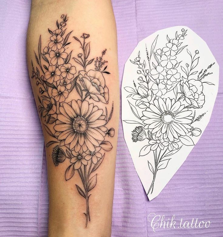 a black and white flower tattoo on the right leg, next to a drawing of flowers