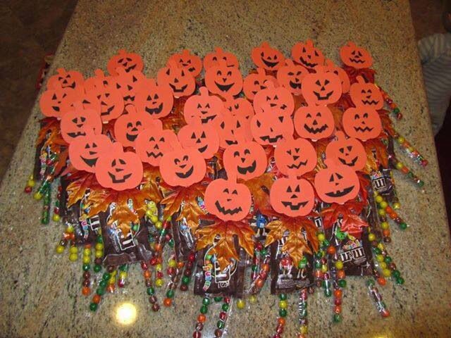 many candy bags with faces on them are sitting on the counter top, all decorated in orange and black