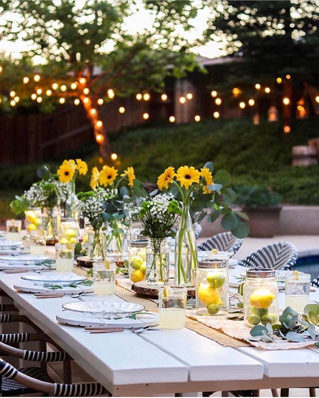 an instagram page with yellow flowers in vases and candles on the long table