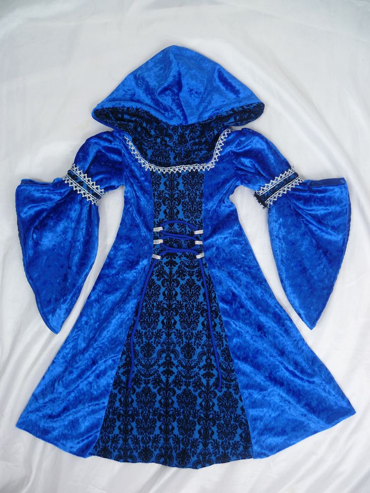 a blue dress is laying on a white sheet and it's hood has been pulled up