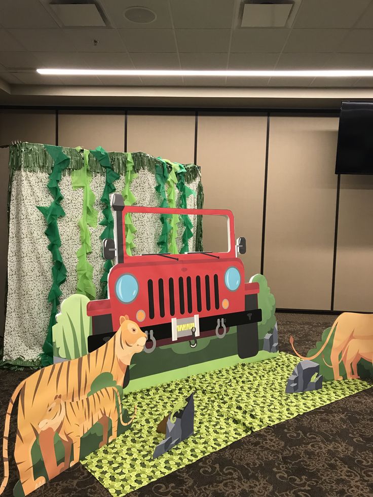 two paper cut out animals standing in front of a jeep and tiger on the ground