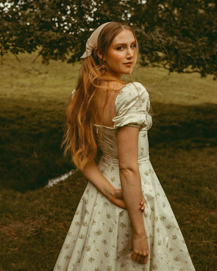 a woman with long red hair wearing a white dress