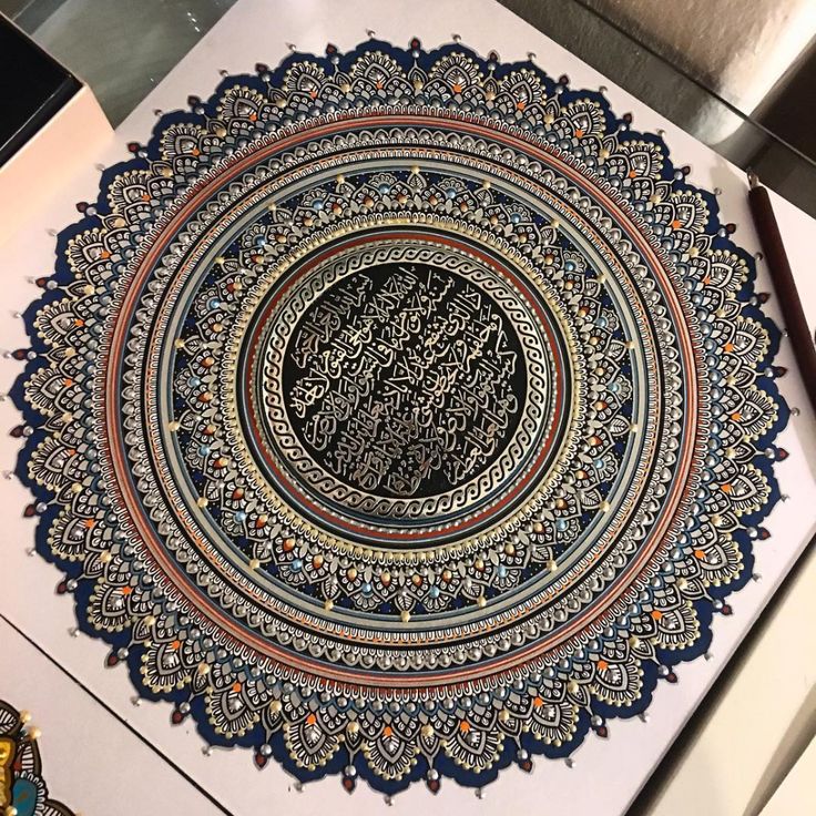 an intricately decorated plate with arabic writing on it, sitting on a counter top