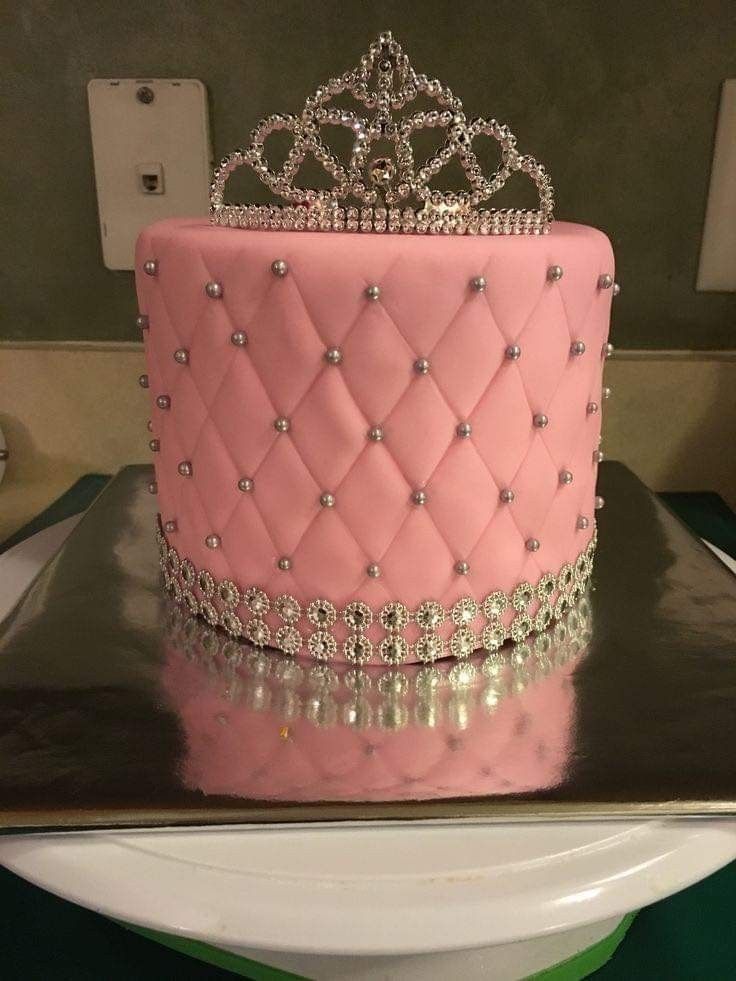 a pink cake with a tiara on top