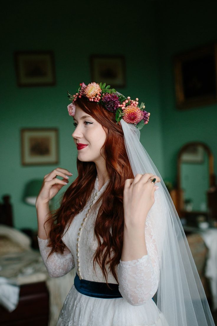 a woman in a wedding dress with flowers on her head