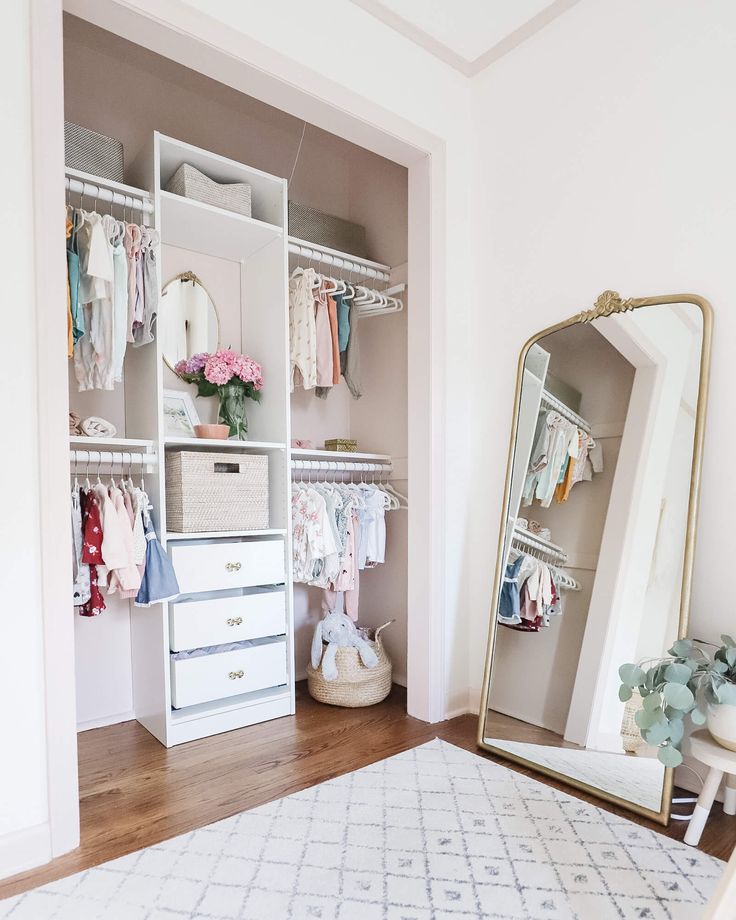 an organized closet with white drawers and baby clothes