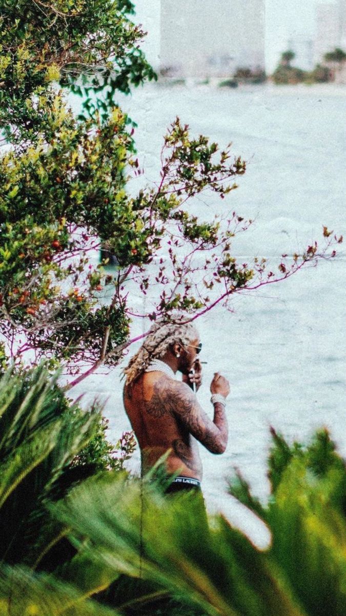 a man with dreadlocks standing by the water