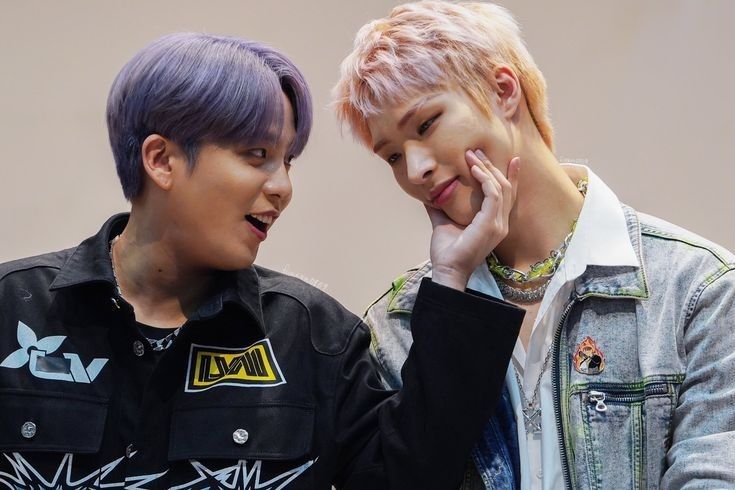 two young men standing next to each other with purple hair and piercings on their ears