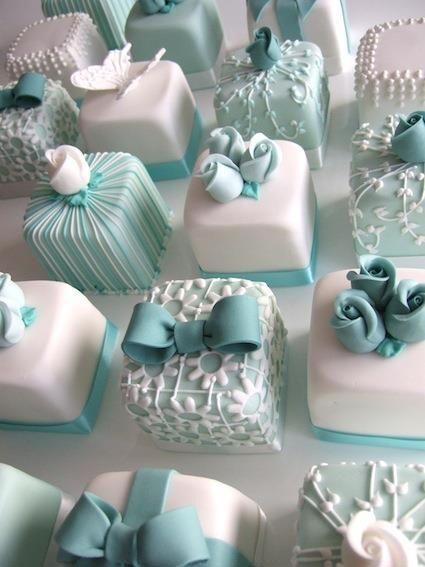 there are many square cakes decorated with bows and ribbons on the top one is blue