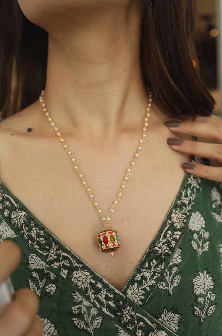 This tribal inspired necklace features a traditionally rich navrattan talismanic pendant resembling a prayer wheel. Starting from intricate meenakari to jadau work presented with an exhibition of colors, the Afya necklace has it all. Closure - Lobster Coming from the collection Seher - our range of Pret Polki for those idyllic mornings where dressing up comes with a side of strong coffee yet a lazy pace. If only Indian jewels had a Friday face, we'd put on our crisp white shirt, slide on the com Traditional Pendant Beaded Necklaces For Festivals, Meenakari Temple Necklace Pendant For Puja, Meenakari Pendant Temple Necklace For Puja, Traditional Long Locket Necklace, Pearl Pendant Necklace As Diwali Gift, Pearl Pendant Necklace For Diwali Gift, Diwali Gift Necklace With Pearl Pendant, Traditional Beaded Necklaces For Rituals, Traditional Temple Necklace With Locket For Festive Occasions