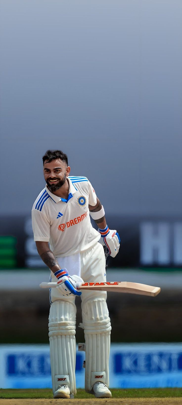 a man holding a cricket bat on top of a field