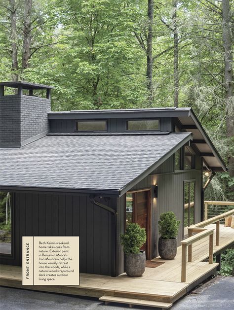 a small house in the woods with stairs leading up to it's roof and windows