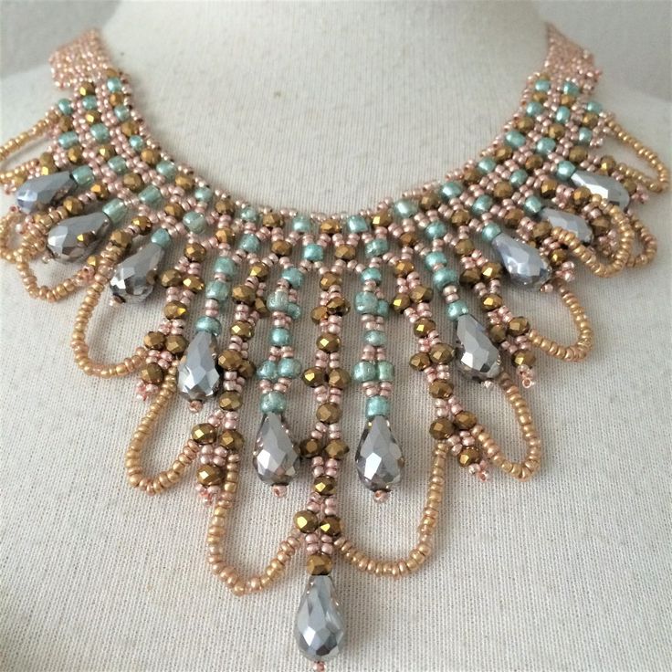 a necklace made with beads and glass stones on a mannequin neckline,