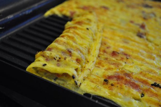 an omelet is being cooked on the grill