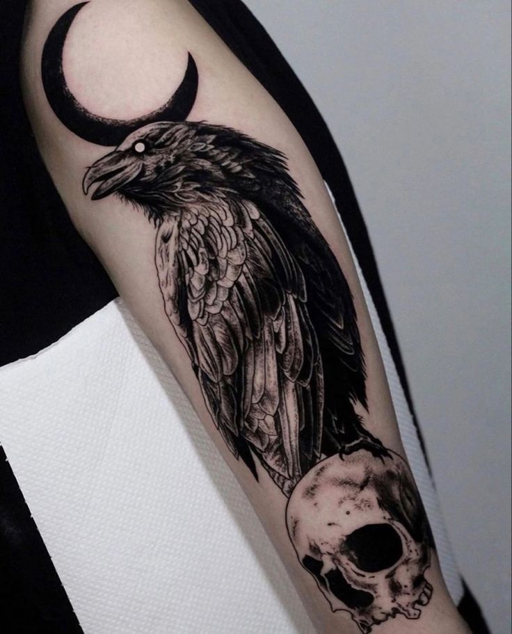 a black and white photo of a bird with a skull on it's arm