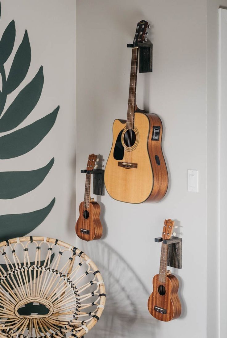 guitars are hanging on the wall next to a fan