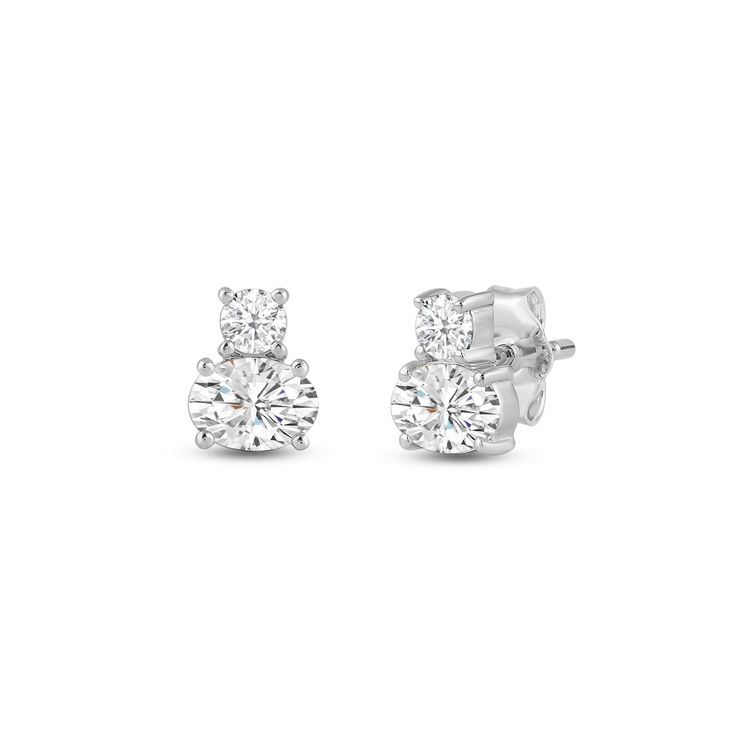 These two-stone stud earrings feature a design that embraces simplicity and elegance. Each stud has a two-stone setting, with a round diamond and an oval diamond set on prongs. The versatile look of this pair makes it suitable for any outfit or occasion. Timeless Oval Brilliant Cut Earrings, Timeless Oval Cubic Zirconia Diamond Earrings, Classic Oval Earrings With Prong Setting, Three-stone Diamond Earrings For Anniversary, Classic Three Stone Diamond Earrings For Anniversary, Classic Three Stone Diamond Earrings, Three Stone Round Earrings For Anniversary, Modern Oval Diamond Earrings, Classic Three Stone Diamond Earrings For Formal Events