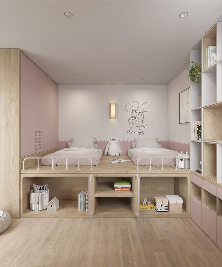 two beds in a room with wooden flooring and pink accents on the walls, along with bookshelves