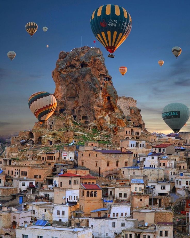 several hot air balloons flying over a city