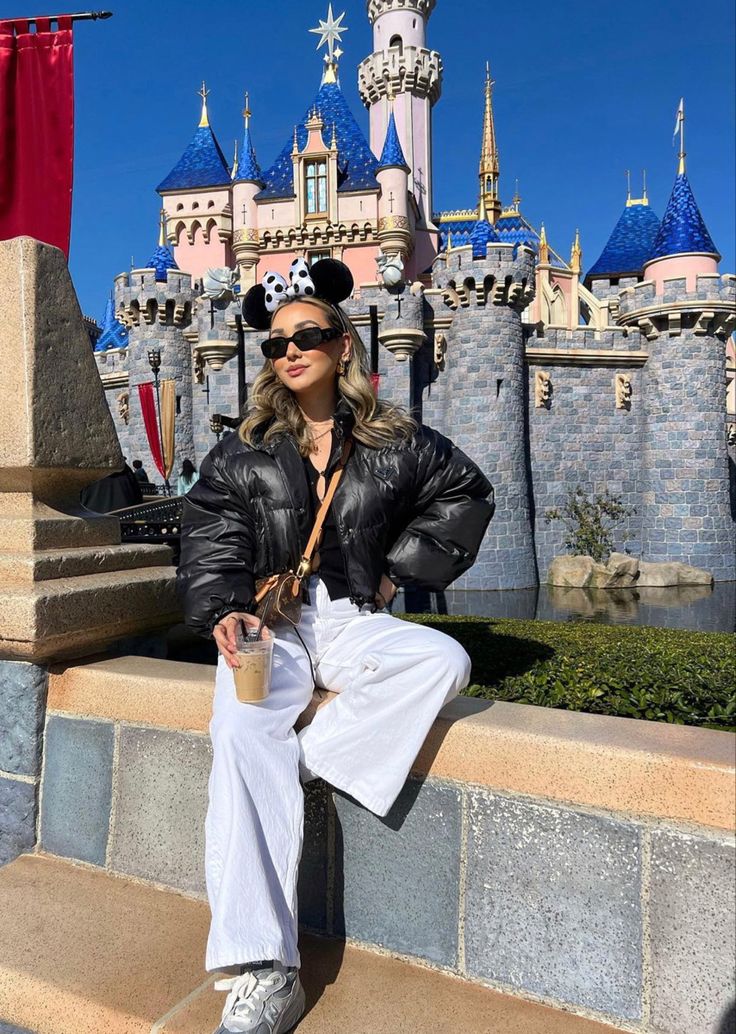 a woman in mickey mouse ears sitting on some steps