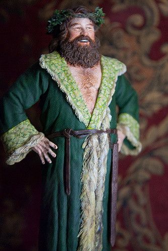 a figurine of a man with a beard wearing a green robe and holding his hands in his pockets