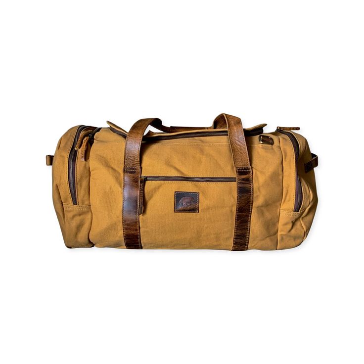 Product image of the 85L Nomad Canvas Duffel Brown Waxed Canvas Duffle Bag For Travel, Travel Bag In Duck Canvas With Leather Patch, Outdoor Canvas Travel Bag With Leather Trim, Travel Bag With Leather Patch And Duck Canvas, Canvas Travel Bag With Luggage Sleeve For Outdoor Activities, Canvas Travel Bag With Luggage Sleeve For Outdoor, Outdoor Canvas Duffle Bag With Rectangular Shape, Rugged Bag With Waxed Finish For Outdoor Activities, Rugged Waxed Canvas Bag For Outdoor Activities