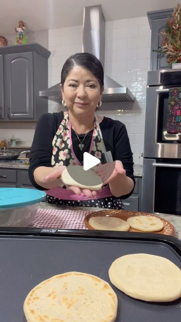 a woman is making tortillas in the kitchen